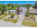 Two-story home with a double deck and two-car garage, surrounded by lush greenery at 503 Chestnut St, Oldsmar, FL 34677