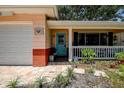 Inviting home entrance featuring a blue door, brick accents, and a cozy covered porch at 5072 98Th Way, St Petersburg, FL 33708