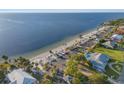 Overhead view of a tranquil beach with shelters, palm trees, parking area, and adjacent waterfront residences at 5537 Sea Forest Dr # 304, New Port Richey, FL 34652