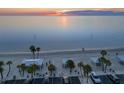 Scenic beach view featuring covered picnic areas, palm trees, parking, and calm bay waters during sunset at 5537 Sea Forest Dr # 304, New Port Richey, FL 34652