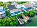 Expansive backyard with a screened pool, boat dock, and lush greenery, perfect for waterfront living at 6509 Dolphin Cove Dr, Apollo Beach, FL 33572