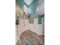 Bright foyer featuring hardwood flooring, white wainscotting, and a white front door at 678 Greenglen Ln, Palm Harbor, FL 34684