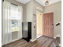 Welcoming entryway featuring wood-look flooring, storage cabinet, and natural light at 7021 White Treetop Pl, Riverview, FL 33578