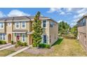 Charming two-story townhouse featuring lush landscaping and a well-maintained lawn at 7021 White Treetop Pl, Riverview, FL 33578