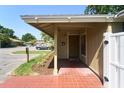 Home featuring a quaint, covered front porch with red tile and garden landscaping at 7205 San Luis Ct, Tampa, FL 33634