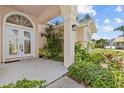 Inviting front entrance with decorative glass doors, framed by manicured landscaping and elegant architectural details at 731 Waterside Ct, Tarpon Springs, FL 34689