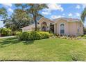 Well-maintained front yard with lush green grass and decorative landscaping, highlighting the home's facade at 731 Waterside Ct, Tarpon Springs, FL 34689