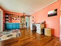 Well-lit living room with coral walls, warm wood floors, and stylish furnishings creating a cozy atmosphere at 808 53Rd E Ave # 142K, Bradenton, FL 34203