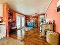 Inviting living room with wood floors, bright coral walls, and a lovely view from the double glass doors at 808 53Rd E Ave # 142K, Bradenton, FL 34203