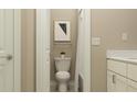 Cozy bathroom featuring modern toilet, shower with curtain, and a stylish wall art, designed for comfort and convenience at 9590 Runaway Breeze Dr, Land O Lakes, FL 34637