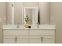 Elegant bathroom featuring double vanity, quartz countertops, and sleek modern faucets, creating a spa-like experience at 9590 Runaway Breeze Dr, Land O Lakes, FL 34637