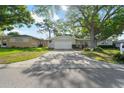 Inviting one-story home featuring a well-manicured lawn, a driveway, and an attached garage at 1105 Oakview Ave, Clearwater, FL 33756