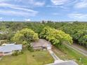 Aerial view of a charming neighborhood, showcasing a one-story brick home with lush tree coverage at 1139 3Rd Nw Ave, Largo, FL 33770