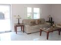 Bright living room features a leather sofa, lamps, and sleek marble floors at 12400 Park Blvd # 111, Seminole, FL 33772