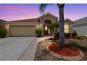 Charming single-story home with landscaped front yard and attached two-car garage at dusk at 12531 Midpointe Dr, Riverview, FL 33578