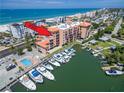 Aerial view of waterfront condos with marina and pool, near beaches at 13235 Gulf Blvd # 502, Madeira Beach, FL 33708