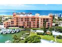 Waterfront condominium complex with multiple balconies, and a boat dock on a sunny day at 13235 Gulf Blvd # 502, Madeira Beach, FL 33708