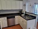Functional kitchen with stainless steel sink, appliances, and white cabinets at 13235 Gulf Blvd # 502, Madeira Beach, FL 33708