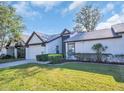 Inviting single-story home boasts a manicured lawn, two-car garage, and classic architectural details at 1353 Camelot Ct, Palm Harbor, FL 34684