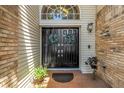 Elegant double front doors with decorative wreaths, brick porch, and stylish outdoor lighting fixture at 13785 Oak Forest S Blvd, Seminole, FL 33776