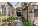 Inviting front entrance featuring double doors, brick accents, decorative plants, and manicured shrubs at 13785 Oak Forest S Blvd, Seminole, FL 33776