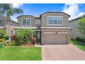 Two-story home with stone accents, mature landscaping, and brick-paved driveway at 1830 Nature View Dr, Lutz, FL 33558