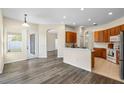 Bright, open-concept kitchen with warm wood cabinets and a breakfast bar, seamlessly flowing into the dining area at 2019 Rutherford Dr, Dover, FL 33527