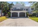 Inviting townhome featuring a two-car garage, well-maintained landscaping, and a paved driveway at 202 S Lincoln Ave, Tampa, FL 33609
