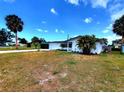 Quaint one-story home with an attached garage, a spacious front yard, and mature landscaping at 2172 University S Dr, Clearwater, FL 33764