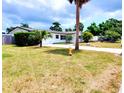 Well-kept single-story home featuring an attached garage, mature trees, and a welcoming front yard at 2172 University S Dr, Clearwater, FL 33764