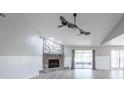 Bright living room with a vaulted ceiling, ceiling fans, and a stone fireplace at 2336 Windsor Oaks Ave, Lutz, FL 33549