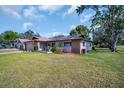 Beautiful single-story home with a manicured lawn and inviting front patio seating area at 2967 Macalpin N Dr, Palm Harbor, FL 34684