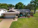 Aerial view of a well-maintained home with lush lawn, a two-car garage, and cozy front patio at 2967 Macalpin N Dr, Palm Harbor, FL 34684