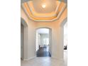 Elegant foyer features a decorative ceiling with recessed lighting and arched entryways leading to other rooms at 416 Durham Shore Ct, Apollo Beach, FL 33572