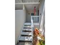 A charming staircase with a white railing leads to the entrance, surrounded by lush greenery and a patriotic windsock at 5115 S Jules Verne Ct, Tampa, FL 33611