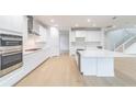 Modern kitchen featuring white cabinetry, a center island, stainless steel appliances, and hardwood flooring at 720 W Peninsular St, Tampa, FL 33603