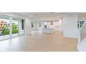 Open-concept living room with natural light, hardwood floors, and access to the kitchen and outdoor lanai at 720 W Peninsular St, Tampa, FL 33603