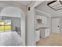 Open floor plan with archway, kitchen with granite countertops, and access to a screened patio at 814 Seabreeze Dr, Ruskin, FL 33570