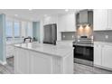 Modern kitchen featuring stainless steel appliances, white cabinets, and island at 9495 Blind Pass Rd # 907, St Pete Beach, FL 33706