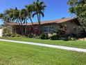 Charming single-story home with beautiful landscaping, mature palm trees, and well-maintained lawn on a sunny day at 101 Madonna Blvd, St Petersburg, FL 33715