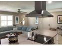 Open-concept living space with modern range hood, comfortable blue sofa, and stylish ceiling fan at 101 Madonna Blvd, St Petersburg, FL 33715