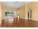Bright living room featuring a hardwood floor and a view of the backyard and an entrance to the kitchen at 1046 Almondwood Dr, Trinity, FL 34655