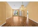 Bright living room featuring a hardwood floor, bright walls, and a large decorative light fixture at 1046 Almondwood Dr, Trinity, FL 34655