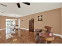 Comfortable living room featuring warm tones, tile flooring, and ample seating space with a ceiling fan at 12467 93Rd Ave, Seminole, FL 33772
