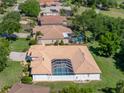 Aerial view showcasing a private backyard pool and patio area in a well-maintained home with a tile roof at 12902 Grand Traverse Dr, Dade City, FL 33525