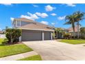 Spacious two-story home featuring a three-car garage and a well-manicured lawn at 12925 Tar Flower Dr, Tampa, FL 33626