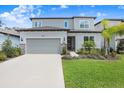 Two-story home showcasing a gray garage door, white accents, and manicured green lawn at 14184 Samoa Hill Ct, Riverview, FL 33569