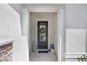 The front door is framed by white columns and decorated with a welcoming wreath and lantern at 14184 Samoa Hill Ct, Riverview, FL 33569