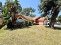 Landscaped front yard with lush green grass and mature trees enhances the appeal of this lovely home at 1813 Landside Dr, Valrico, FL 33594