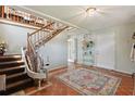 Welcoming foyer with staircase featuring a chair lift and a decorative rug on the tiled floor at 1842 Bayou Grande Ne Blvd, St Petersburg, FL 33703